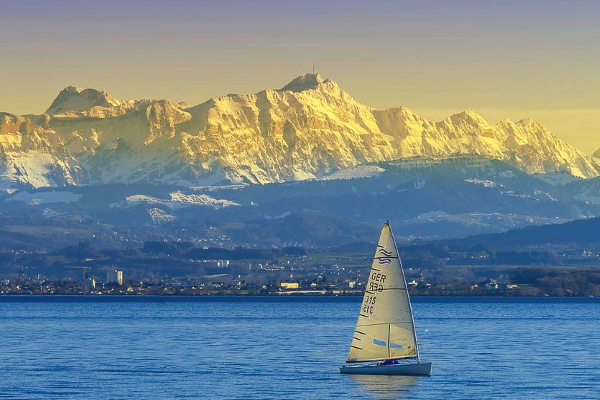 Sailing boat Lake Constande, mountains in the back